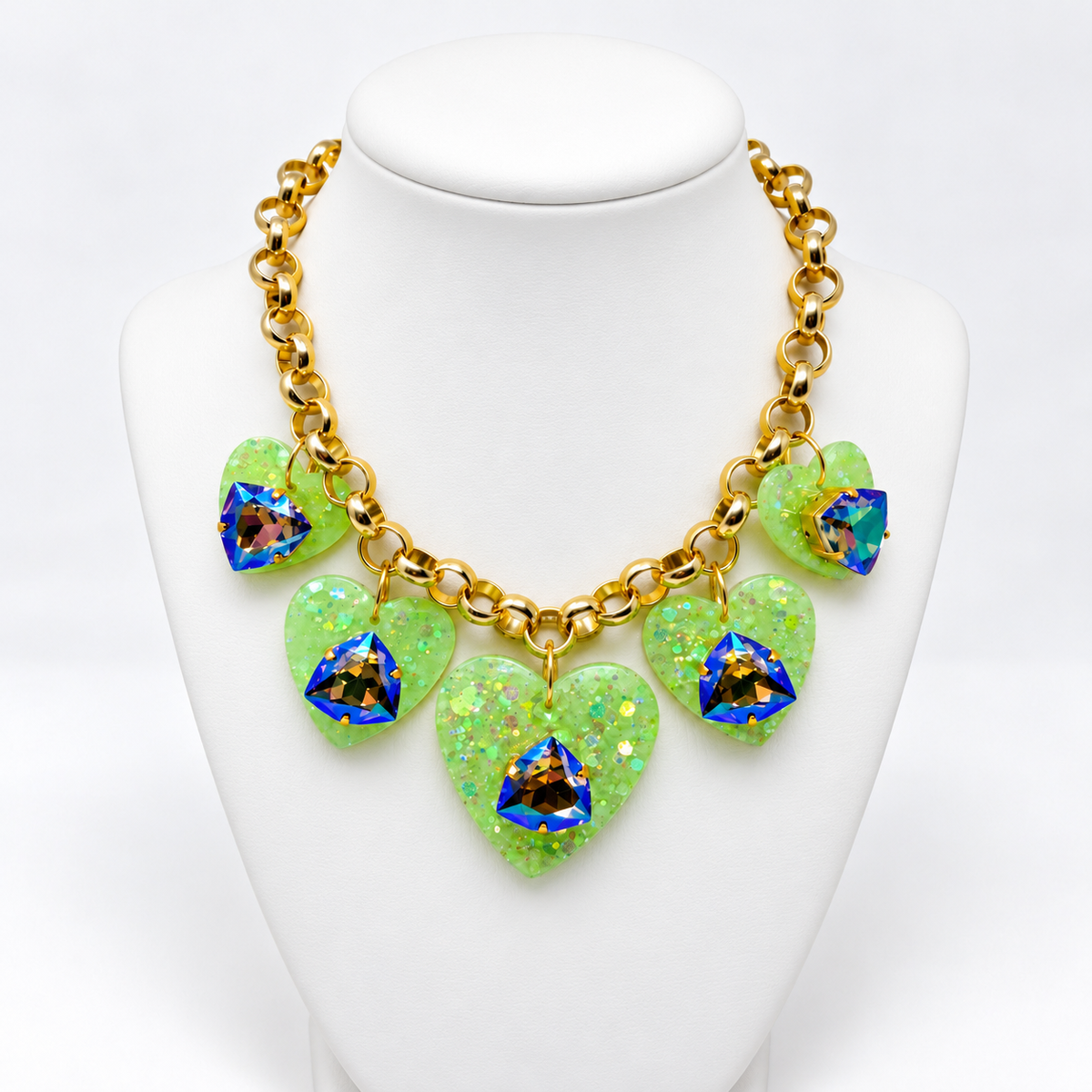 Green heart charm necklace displayed on a white jewelry bust.