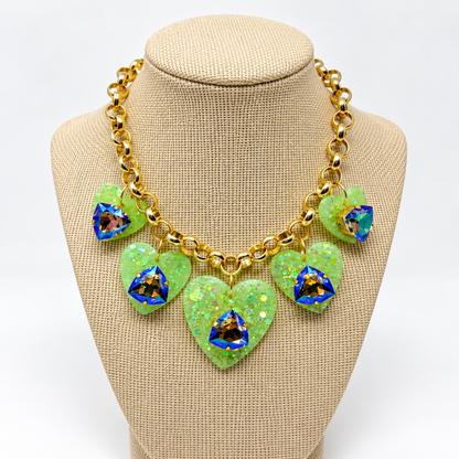 Gold-plated heart charm Swarovski necklace displayed on a linen jewelry bust.
