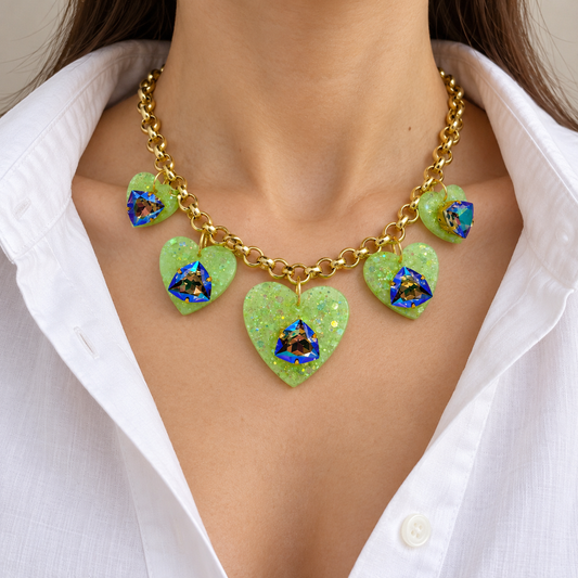 Green heart charm Swarovski crystal necklace worn with a white blouse.
