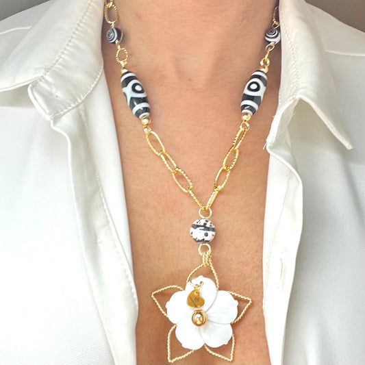Black and white necklace with gold chain and mother of pearl flower pendant