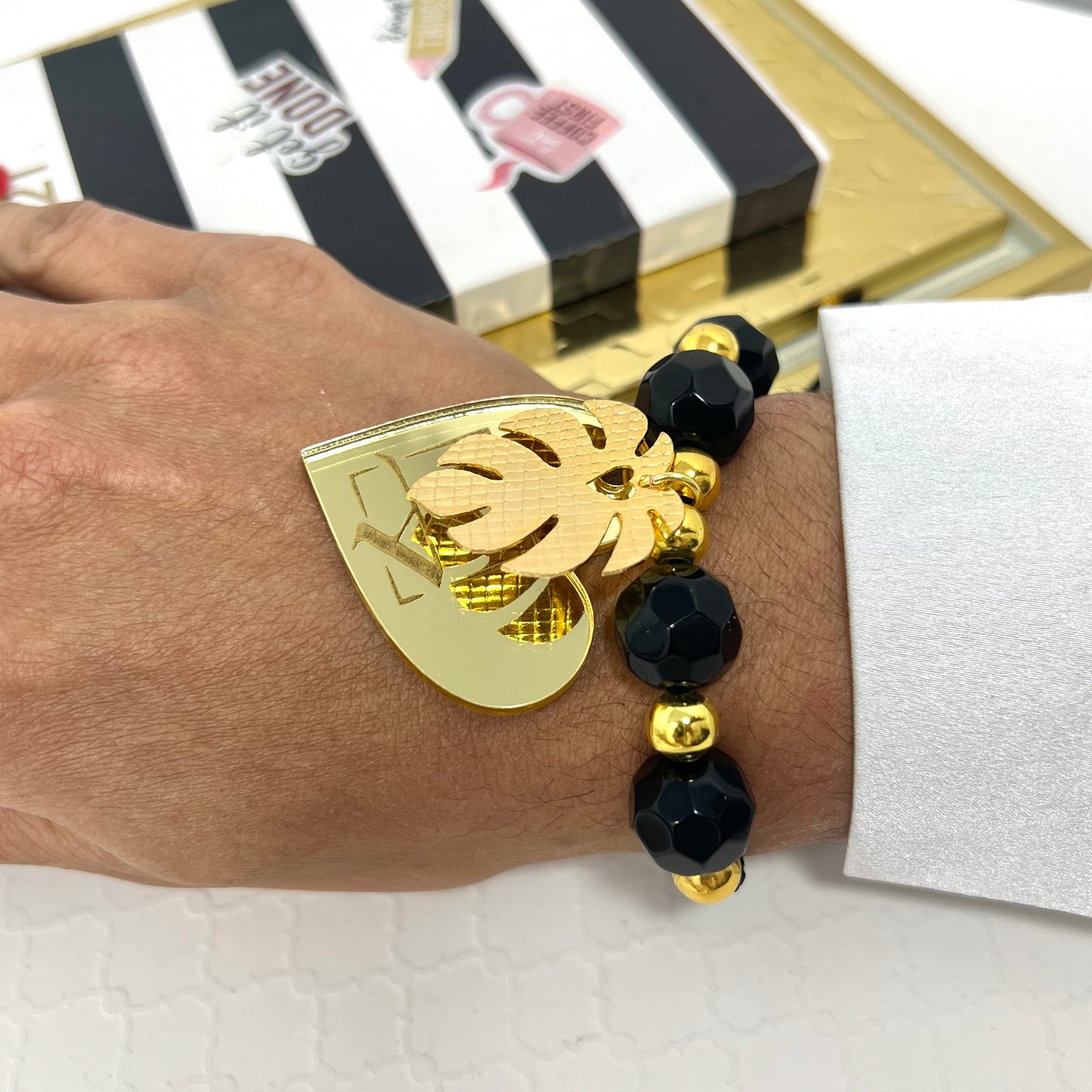 Black bracelet woven in adjustable macrame with gold laminated beads