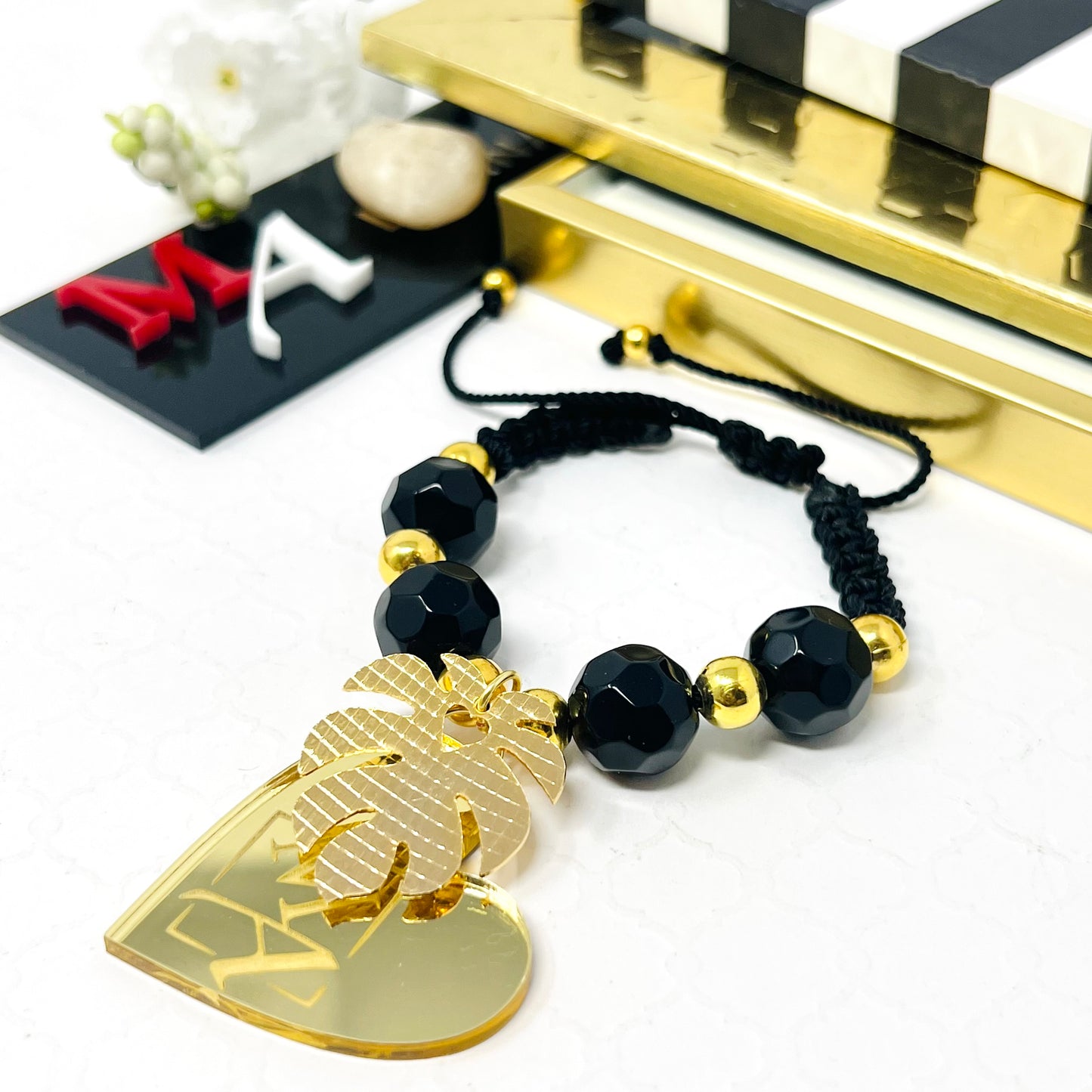 Black bracelet woven in adjustable macrame with gold laminated beads