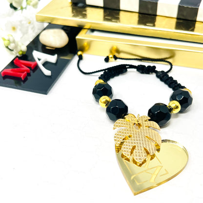 Black bracelet woven in adjustable macrame with gold laminated beads