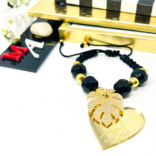 Black bracelet woven in adjustable macrame with gold laminated beads