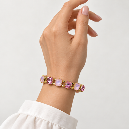Pink bracelet with cushion-cut crystals in two shades of pink and gold-tone detailing, shown on the wrist.