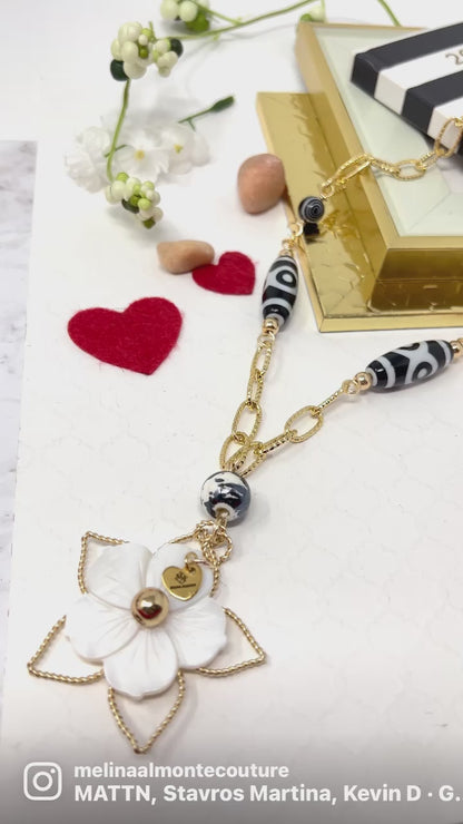 Black and white necklace with gold chain and mother of pearl flower pendant